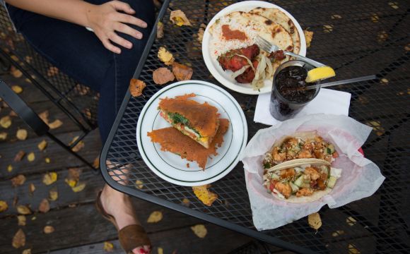 tacos and other small dishes sitting upon a table 