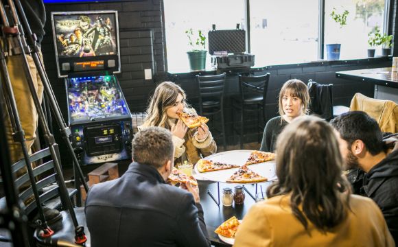 Five friends eating pizza