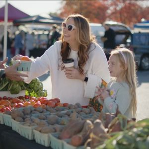 mother and daughter shopping for produce at farmers market 