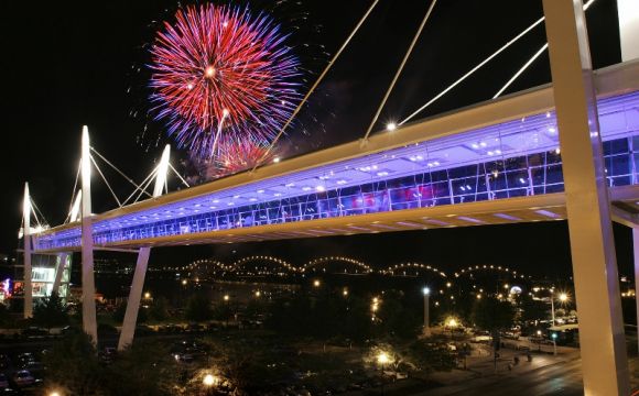 the skybridge in downtown davenport iowa during the 4th of july with a firework going off in the background 