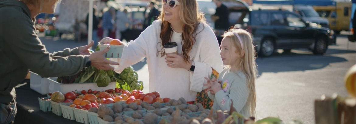 mother and daughter shopping produce at farmers market